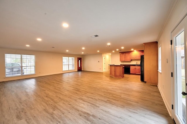 unfurnished living room featuring ornamental molding and light hardwood / wood-style floors