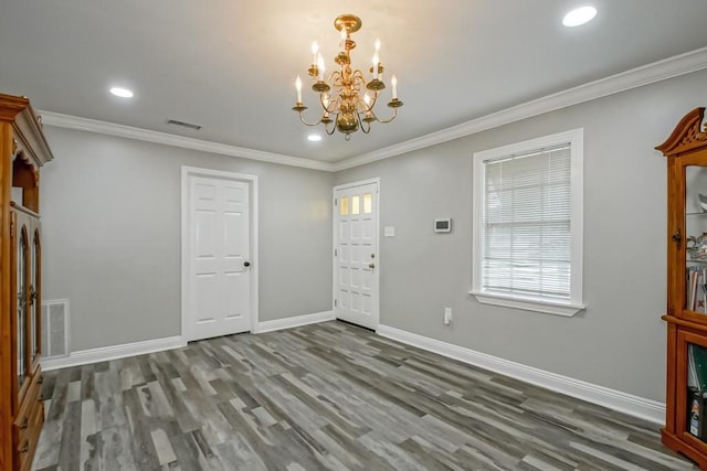 foyer entrance featuring a notable chandelier, crown molding, and wood-type flooring