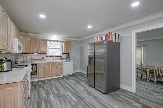 kitchen with ornamental molding, light brown cabinets, white appliances, and light hardwood / wood-style floors