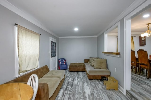 living area with a notable chandelier, crown molding, and wood-type flooring