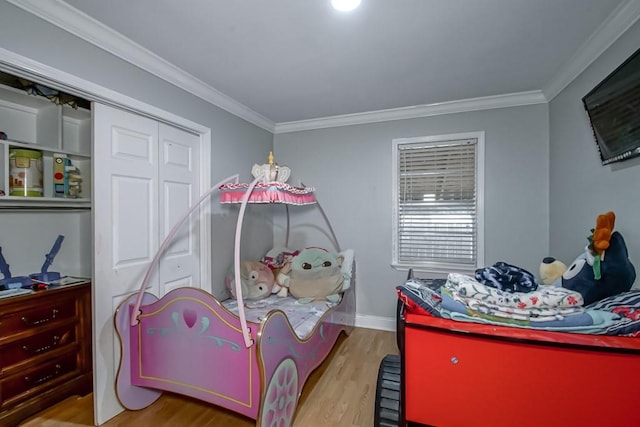 bedroom with a closet, ornamental molding, and light hardwood / wood-style flooring