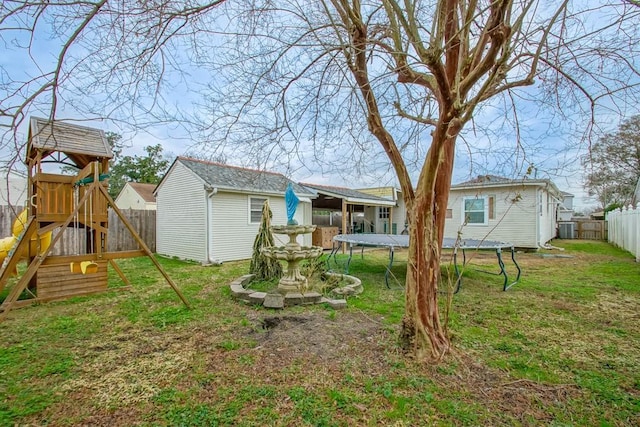 rear view of property featuring a trampoline, a yard, a playground, and a storage unit