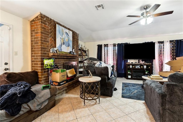 living room featuring a brick fireplace, light tile patterned floors, vaulted ceiling, and ceiling fan