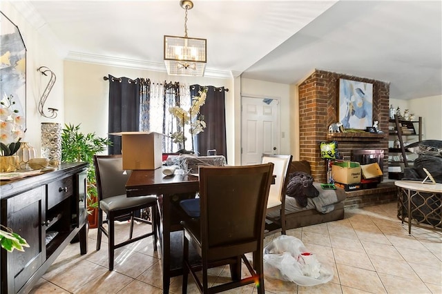 dining area featuring crown molding, a notable chandelier, a brick fireplace, and light tile patterned floors