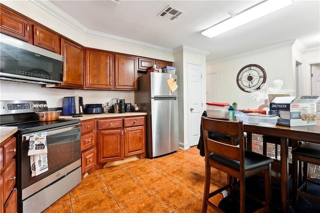 kitchen with ornamental molding, appliances with stainless steel finishes, and light tile patterned floors