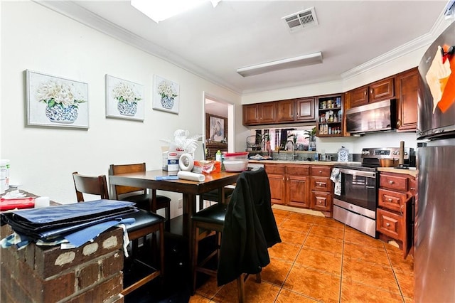 kitchen with crown molding, appliances with stainless steel finishes, sink, and light tile patterned floors