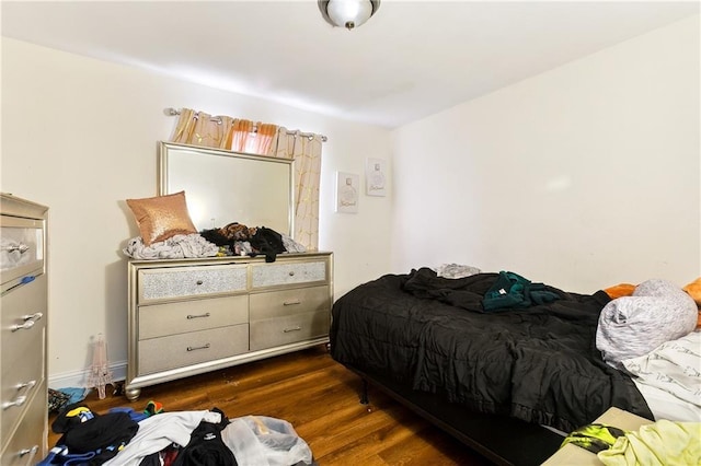 bedroom with dark hardwood / wood-style flooring