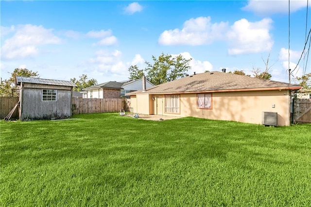 back of house featuring a storage shed, a lawn, and a patio