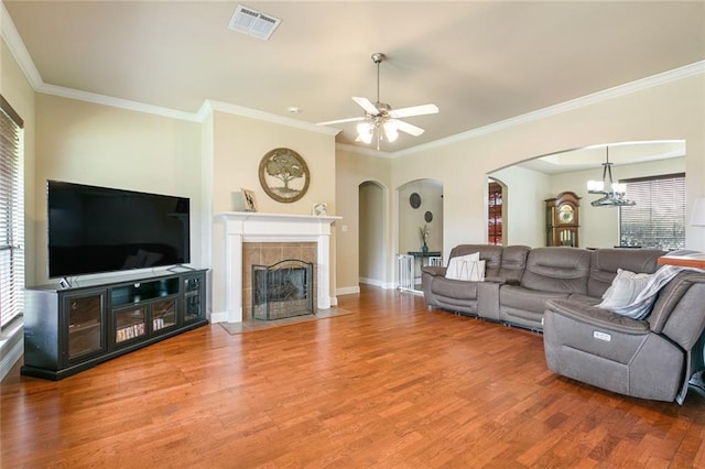 living room with a fireplace, wood-type flooring, and ornamental molding