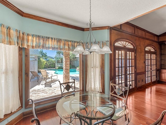 dining space with hardwood / wood-style flooring, crown molding, and a textured ceiling