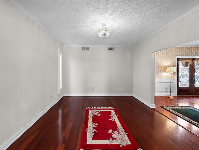 spare room with ornamental molding, a textured ceiling, and a notable chandelier