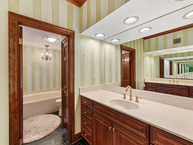 bathroom featuring vanity, toilet, a bath, tile patterned floors, and a textured ceiling