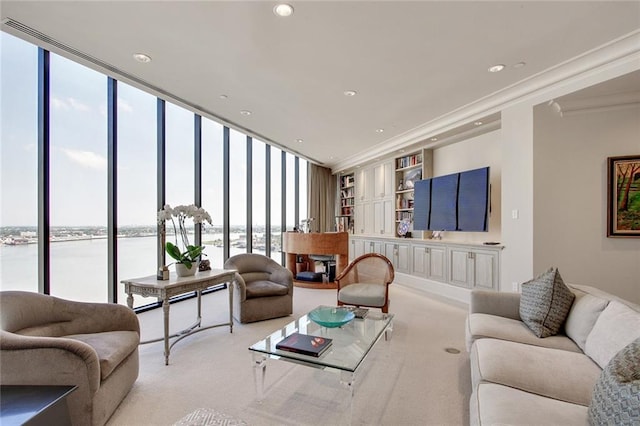 carpeted living room with expansive windows, crown molding, and a water view