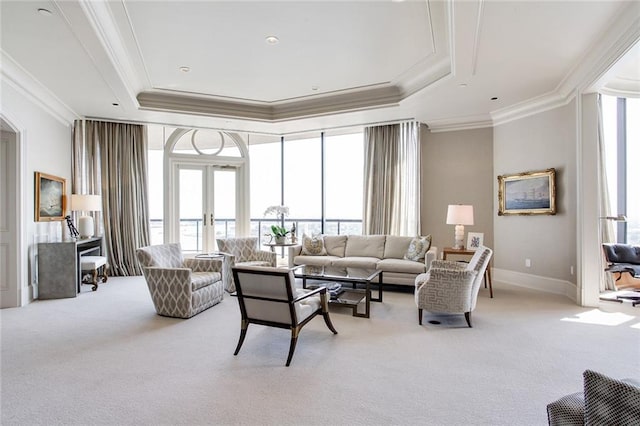 carpeted living room featuring french doors, a healthy amount of sunlight, and a raised ceiling