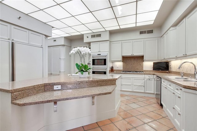 kitchen featuring white cabinetry, sink, decorative backsplash, and appliances with stainless steel finishes