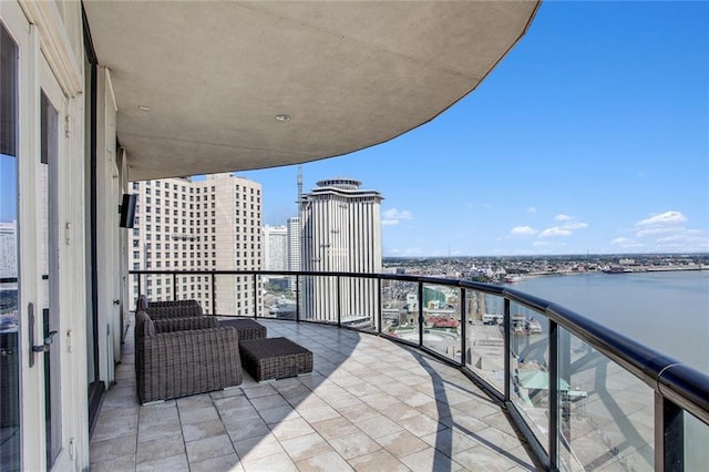 balcony featuring an outdoor living space and a water view