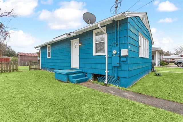 rear view of property featuring a lawn