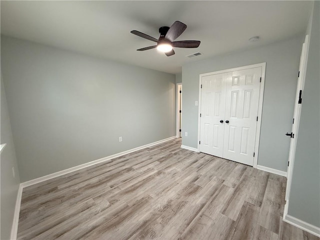 unfurnished bedroom with ceiling fan, a closet, and light hardwood / wood-style flooring