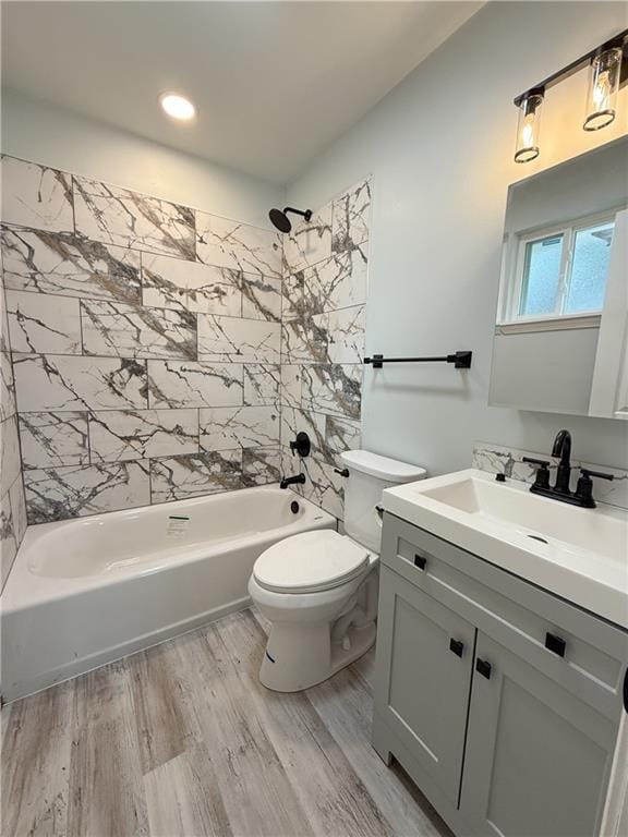 full bathroom featuring tiled shower / bath combo, wood-type flooring, vanity, and toilet