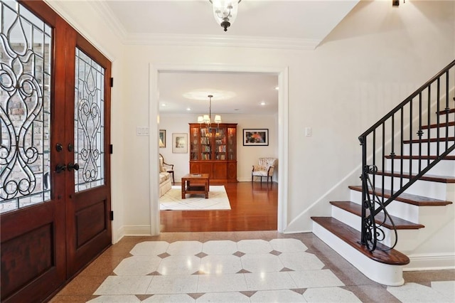 foyer featuring ornamental molding, french doors, and a chandelier