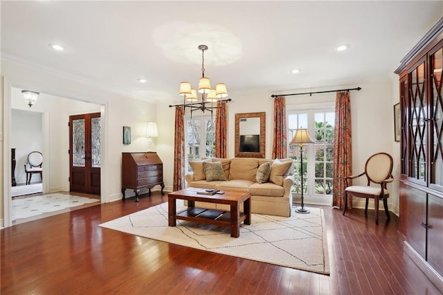 living room featuring crown molding, dark wood-type flooring, a notable chandelier, and french doors