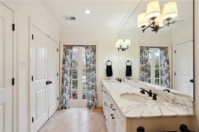 bathroom featuring tile patterned flooring, ornamental molding, a notable chandelier, and vanity