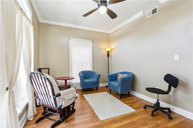 sitting room with ceiling fan, ornamental molding, a healthy amount of sunlight, and light wood-type flooring