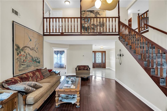 living room featuring a towering ceiling and hardwood / wood-style floors