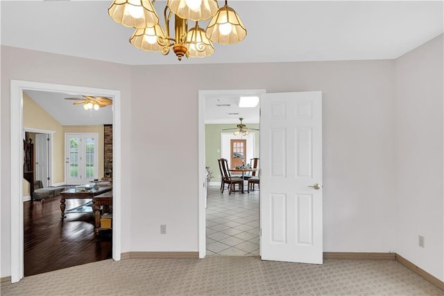 empty room with ceiling fan with notable chandelier and vaulted ceiling