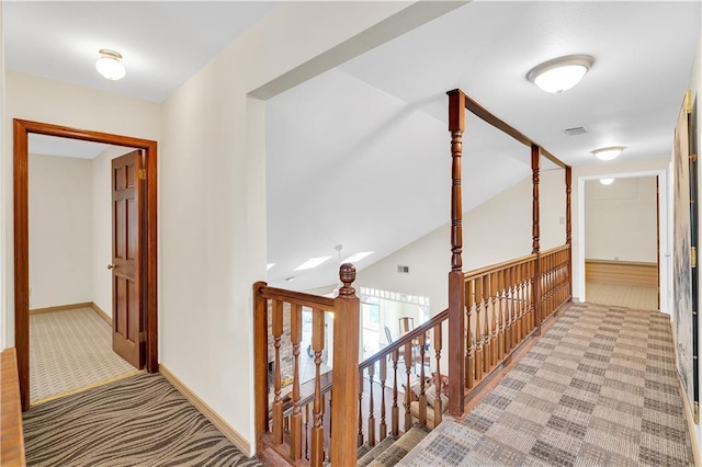 corridor with light carpet and lofted ceiling