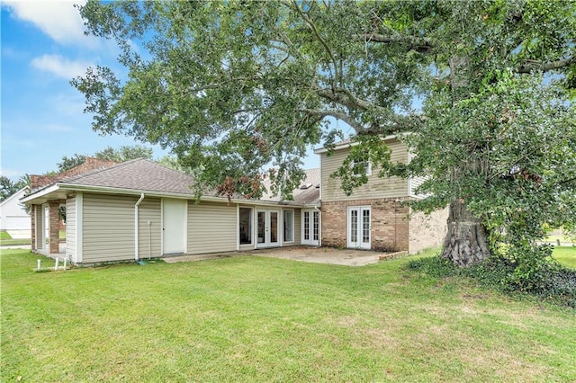 back of property with a yard and french doors