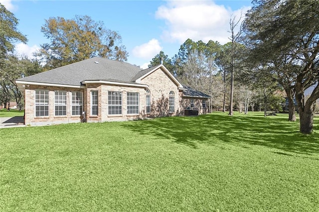 rear view of property featuring a lawn