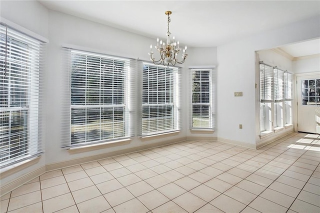 unfurnished dining area featuring a wealth of natural light, light tile patterned floors, and a chandelier