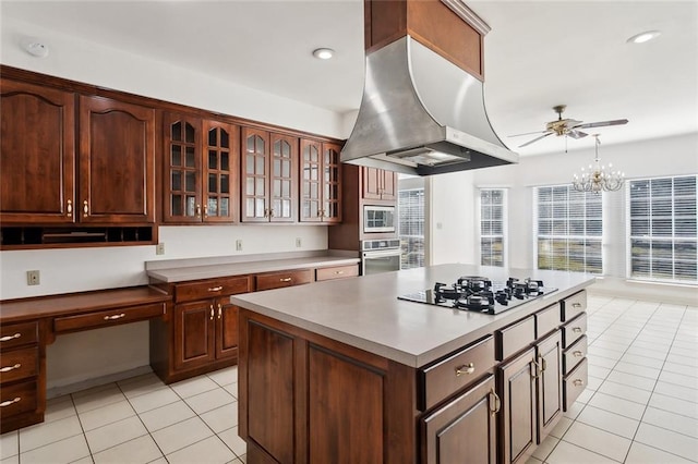 kitchen featuring a center island, built in desk, appliances with stainless steel finishes, pendant lighting, and island exhaust hood