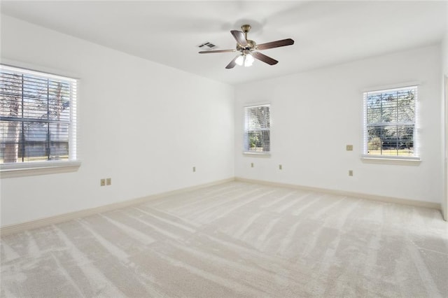 spare room featuring plenty of natural light, light colored carpet, and ceiling fan