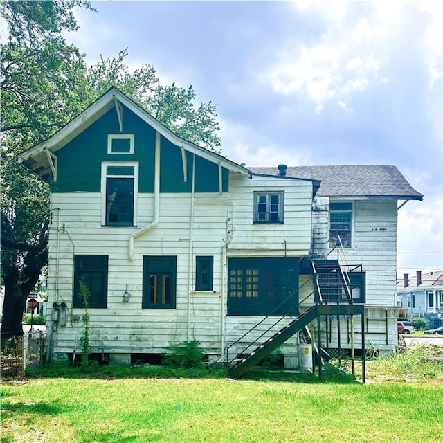 rear view of property featuring a yard