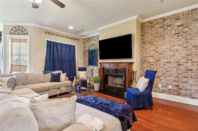 living room featuring ornamental molding, brick wall, hardwood / wood-style floors, and ceiling fan