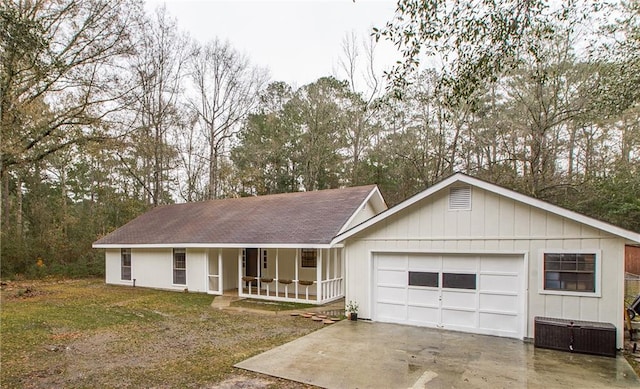 single story home featuring a porch, a garage, and a front lawn