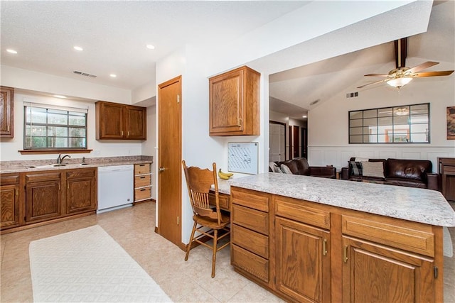 kitchen with sink, ceiling fan, vaulted ceiling with beams, white dishwasher, and built in desk