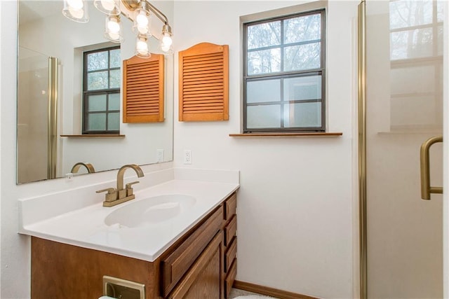 bathroom featuring an enclosed shower, vanity, and a notable chandelier