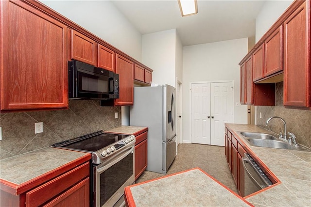 kitchen featuring sink, decorative backsplash, tile counters, and stainless steel appliances