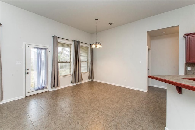 unfurnished dining area with a notable chandelier