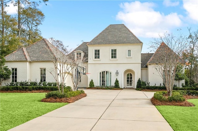 french country style house featuring a front yard