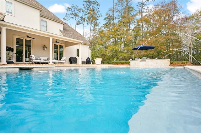 view of swimming pool with pool water feature and ceiling fan