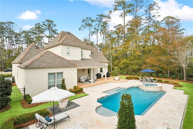 view of swimming pool with an in ground hot tub, a lawn, and a patio