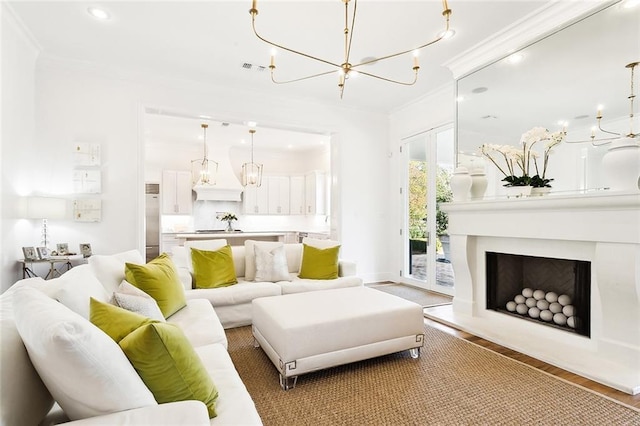 living room featuring a notable chandelier, ornamental molding, and hardwood / wood-style floors