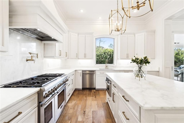 kitchen featuring light wood-type flooring, custom exhaust hood, white cabinets, and appliances with stainless steel finishes