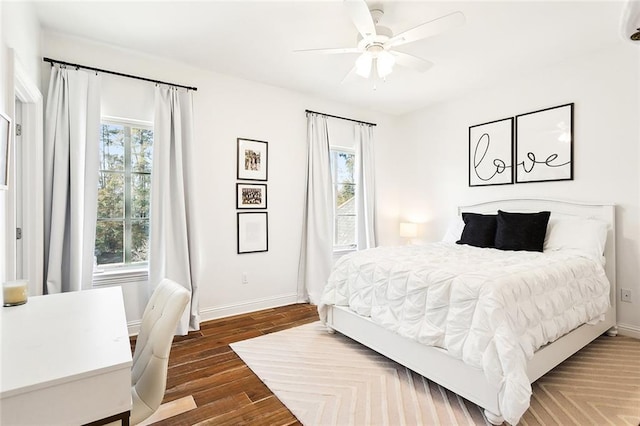 bedroom featuring multiple windows, dark wood-type flooring, and ceiling fan