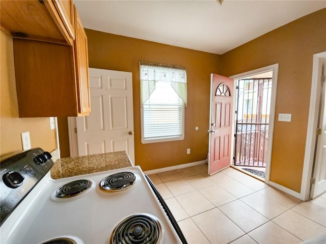 kitchen featuring light tile patterned floors and electric range