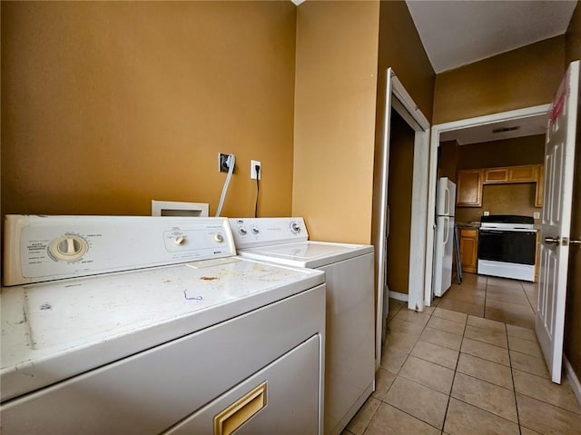 washroom featuring light tile patterned flooring and washer and clothes dryer